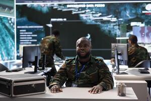 Army personnel in a high tech command center attends a videocall meeting and communicating crucial information from surveillance systems and cctv. Support national security operations. photo