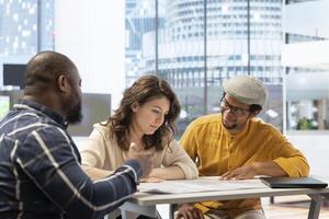 Real estate agent presenting the property investment opportunity available from leasing the new high class office space. Realtor evaluating blueprints and building layouts at desk. photo