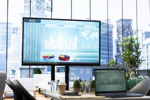 Empty boardroom setup with a computer displaying financial data, facilitates effective communication and strategy development for a successful business project. Performance goals. photo