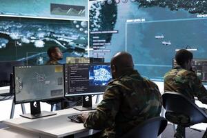 Military specialist in a high tech control center managing satellite radar surveillance, collecting intelligence on cctv computer systems. Interpreting real time data to ensure national defense. photo
