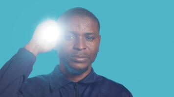 Headshot portrait of security employee tasked with evicting trespassers, turning on flashlight. Close up shot of patrolling agent using lantern, spotting intruders, studio background, camera A photo