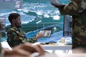 Military staff in a high tech command post work on intelligence gathering, integrating real time surveillance and maintaining security protocols. National defense and strategic federal operations. photo