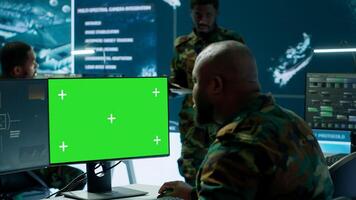 Soldier analyzing real time data next to green screen in high tech military office, processing intelligence for field operations and coordinating strategic missions to ensure national interests. Camera A. photo