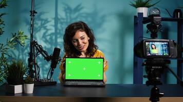 Online show host doing isolated screen laptop unboxing content, filming with professional camera. Tech expert doing chroma key notebook product placement, recording with advanced gear, camera B photo