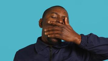 Portrait of security job employee yawning while at work detaining perpetrators, feeling tired. Patrol guard feeling exhausted after long night shift, isolated over studio background, camera A photo