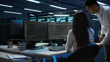 Team of programmers in data center responsible for installation and repair of networking equipment solving tasks. Teamworking colleagues doing maintenance on server room infrastructure, camera B photo