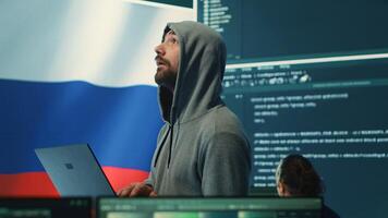 Russian cyber forces operative working with computer systems in a governmental hacking room. Inflicting cyberterrorism, fake news and dangerous brainwashing, digital mercenary activities. Camera A. photo