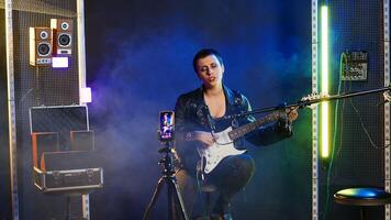 Punk rock musician hosting a live event concert on online streaming session, singing heavy metal alternative music in the studio. Artist doing a digital performance on social media. Camera B. photo
