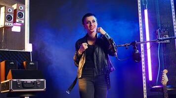 Superstar female artist throwing air punches in celebration for something, rebellious confident attitude. Musician with an energetic edgy vibe determined for a great performance. Camera A. photo