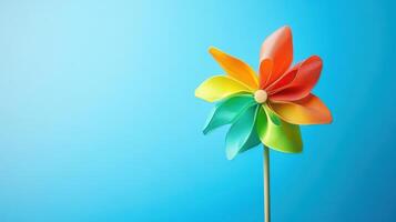 Colorful pinwheel spins gently against a bright blue background in a cheerful display of childhood nostalgia and fun photo