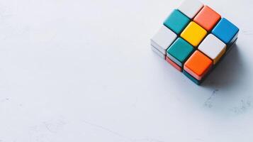 Colorful Rubik's Cube rests on a white surface, inviting puzzle enthusiasts to solve its complexities in a relaxing environment photo