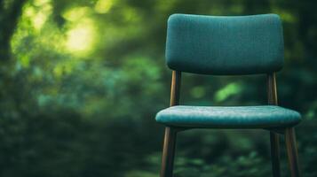 Empty chair placed in a lush green forest with natural light filtering through the trees photo