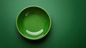 A green bowl on a table with a green background photo