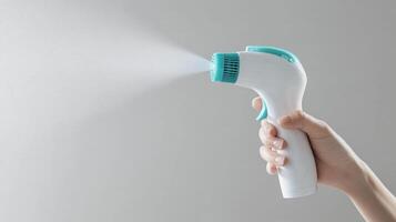 Handheld spray device releasing mist for moisturizing or cleaning purposes in a neutral setting photo