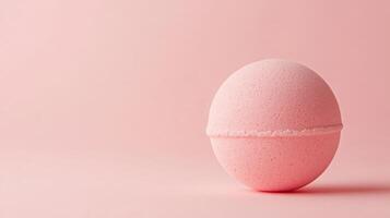 Pink bath bomb resting on soft pink background, perfect for a soothing and relaxing bath experience at home photo