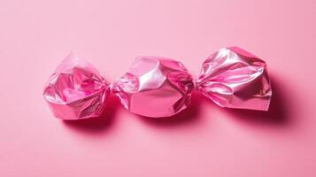 Bright pink wrapped candies arranged on a pastel pink background create a playful and vibrant display for sweet treats photo
