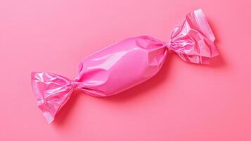 Bright pink candy wrapper on vibrant pink background showcases colorful confectionery delights photo