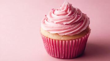 A cupcake with pink frosting on a pink background photo