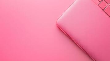 Top view of a pink laptop on a pink background photo