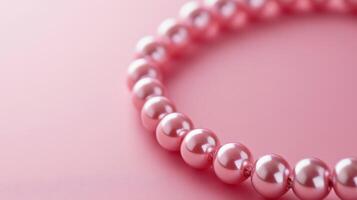 Elegant pink pearl necklace resting on a soft pink background, showcasing its luster and unique design photo
