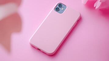 A pink iphone case laying on a pink surface photo