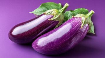 Freshly harvested eggplants on a vibrant purple background highlighting their smooth skin and rich color photo
