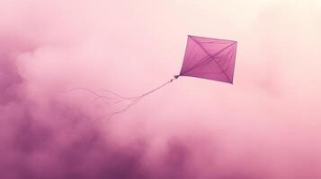 A kite flying in the sky with a pink background photo