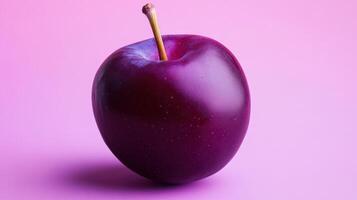 A purple apple on a pink background photo