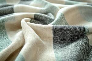 Soft plaid blanket with folds creating cozy texture ideal for background. photo