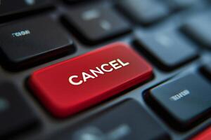 Red cancel key on black keyboard is bringing cancellation request photo