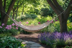 Relaxing hammock hanging between two trees in lush garden photo