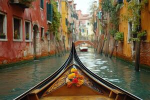 Gondola sailing on canal in venice with flowers and bridge in background photo