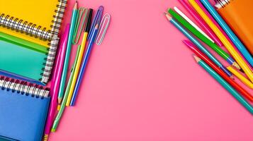 Colorful Stationery Supplies and Notebooks on Pink Background photo