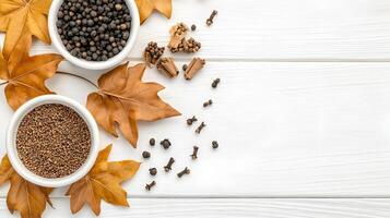 Assorted Spices with Autumn Leaves on White Wooden Background photo
