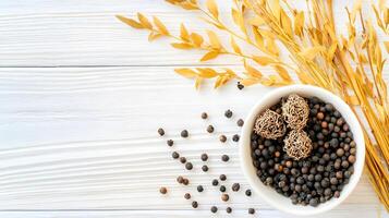 Bowl of Black Spices with Dried Flowers on Wooden Background photo