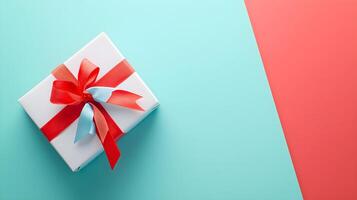 Gift Box with Red Ribbon on Blue and Coral Background photo