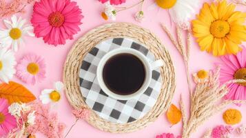 Cozy Coffee Cup Surrounded by Bright Floral Arrangement on Pink Background photo
