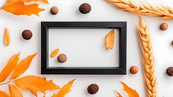 Autumn Still Life with Leaves, Nuts, and Empty Frame on White Surface photo