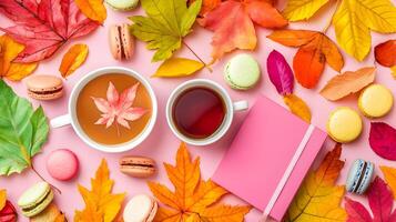 Autumn Tea and Macarons with Colorful Leaves on Pink Background photo