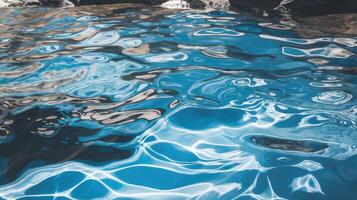 A serene view of rippling blue water, reflecting natural tones and sunlight, creating a tranquil and inviting atmosphere. photo