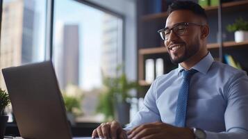 Professional young man working on laptop in sunny office setting photo