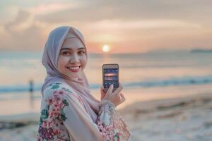 Woman in Hijab Taking Picture of Sunset. photo