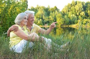 Portrait of senior couple resting in park photo