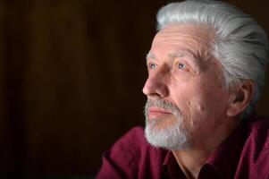 close-up portrait of a senior man thinking about something photo