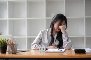 businesswoman feeling stressed by calculating numbers Calculate profits and taxes for clients with the calculator. photo