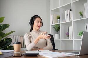Young Asian student studies online about graphs and statistics. Happy Zoom call studying with laptop computer photo