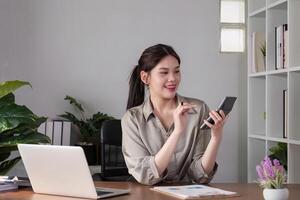 Young Asian business woman sitting in the office using a calculator to calculate business numbers. photo