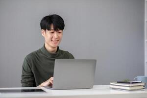 Portrait of a handsome young office worker intently studying how to do a presentation project on a laptop in his office. photo