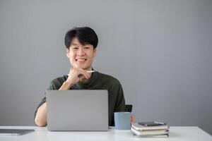 Portrait of a handsome young office worker intently studying how to do a presentation project on a laptop in his office. photo