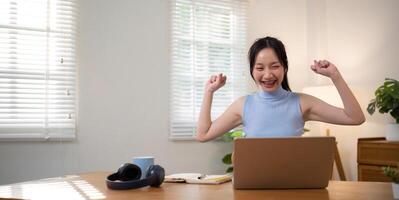 Asian college student sit at home studying online using a calling program on their laptop. photo